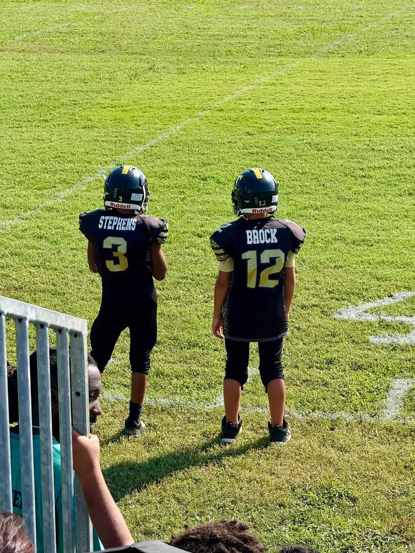 Brantly Stephens, number 3, and a Temple Tigers teammate, number 12, watching together from the sideline