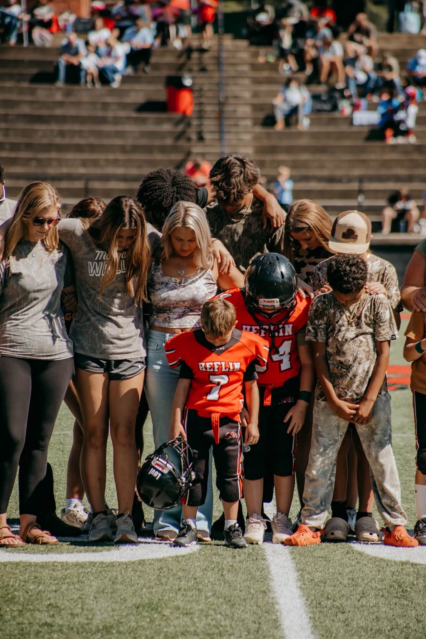 Family members and children standing together at midfield.