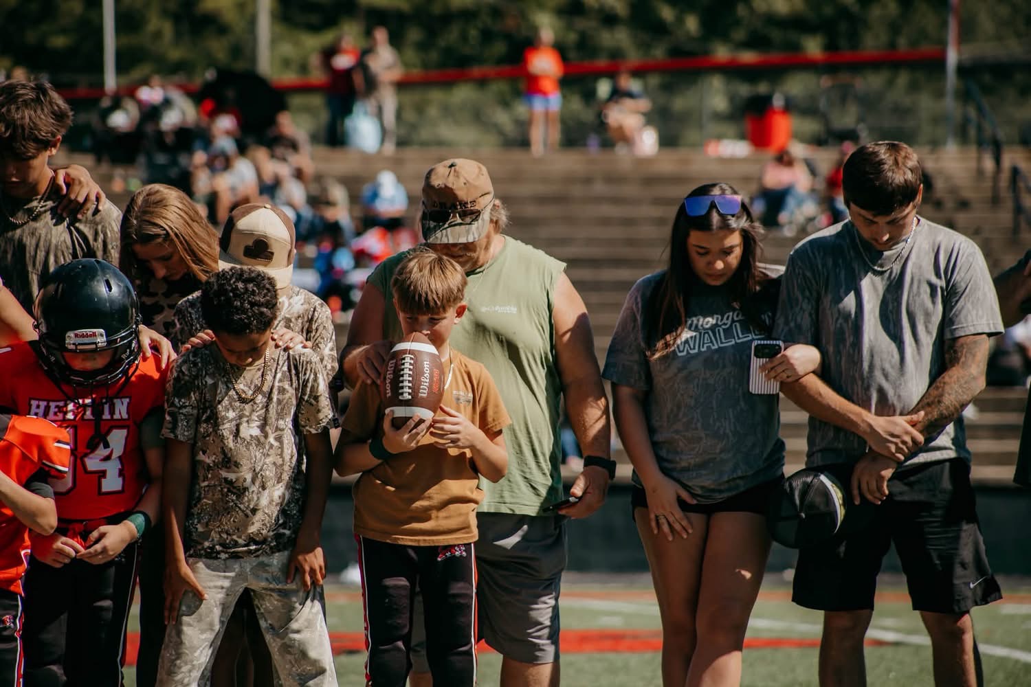 Children and loved ones standing together on the field.